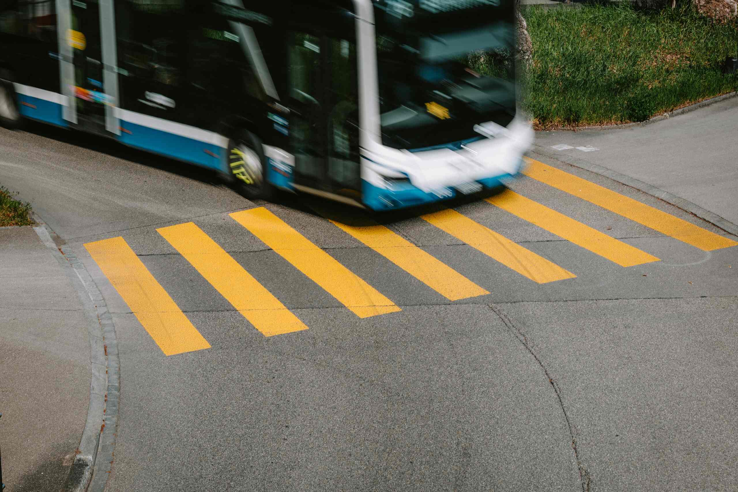 A yellow school bus drives down a road under the protection of bus accident lawyers in Michigan.