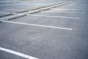 Empty asphalt lot with painted stalls served by a Detroit, MI parking lot accident lawyer.